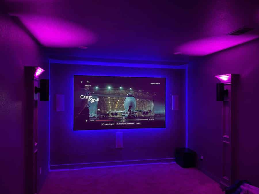 home theater space with purple ambient lighting and a large backlit TV display.