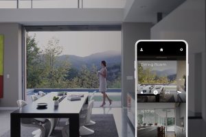 A woman walking between the pool and the kitchen. An overlayed Savant app displays the dining room and kitchen.