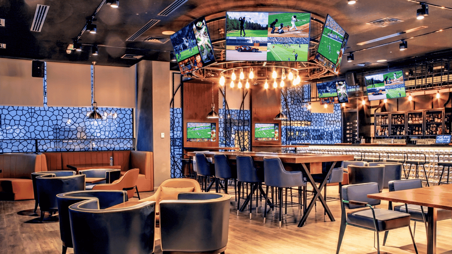 A restaurant with several tables, pendant lights, and in-ceiling Focal speakers.