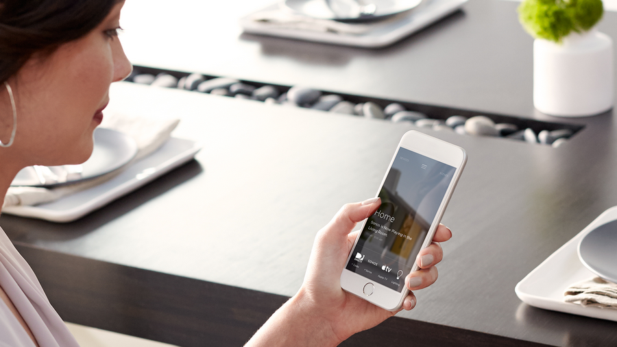 A woman looking at her Savant system’s app on her smartphone.