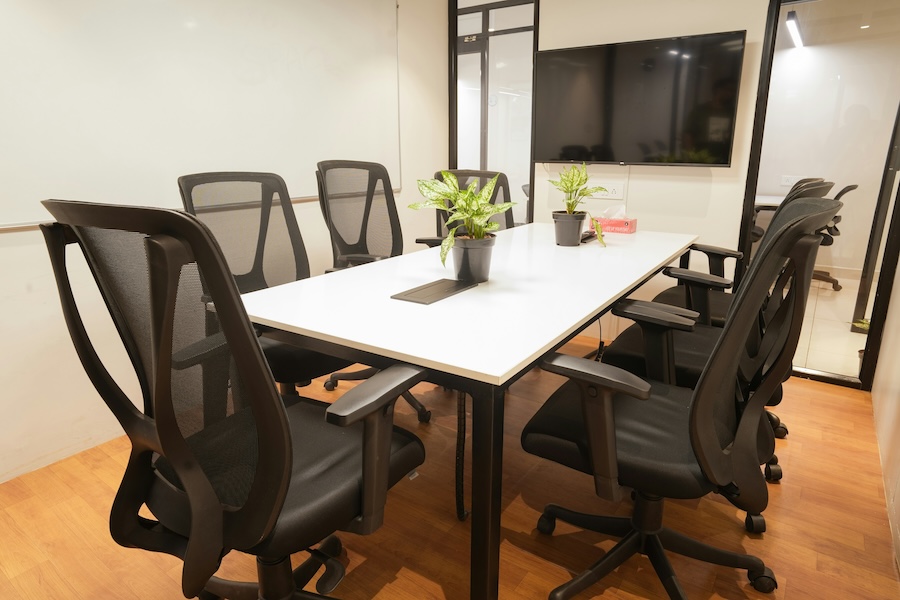 corporate meeting room with various lighting fixtures and an on-wall TV display for videoconferencing.