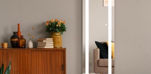 A body-length Séura TV mirror in an office space or room.