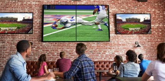 A restaurant or bar showing patrons viewing different sports games on several TVs.