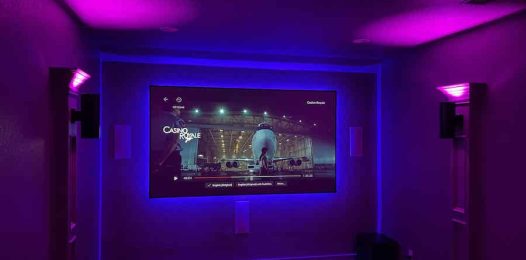 home theater space with purple ambient lighting and a large backlit TV display.