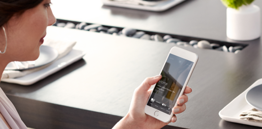 A woman looking at her Savant system’s app on her smartphone.