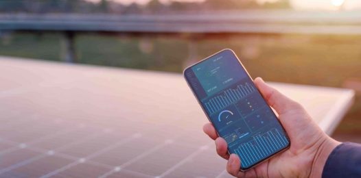 closeup of a hand holding a smartphone with an energy management interface showing.