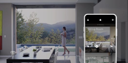 A woman walking between the pool and the kitchen. An overlayed Savant app displays the dining room and kitchen.