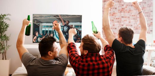 A group of friends celebrating while watching a basketball game.