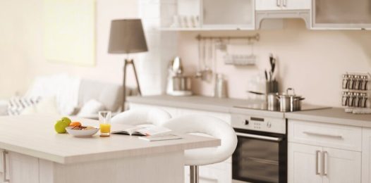 A kitchen space featuring an island with two seats at the center.
